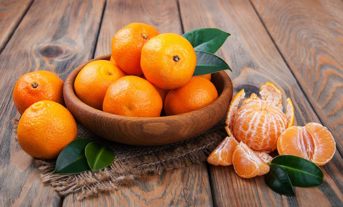 A bowl of oranges and mandarins placed on a table Image
