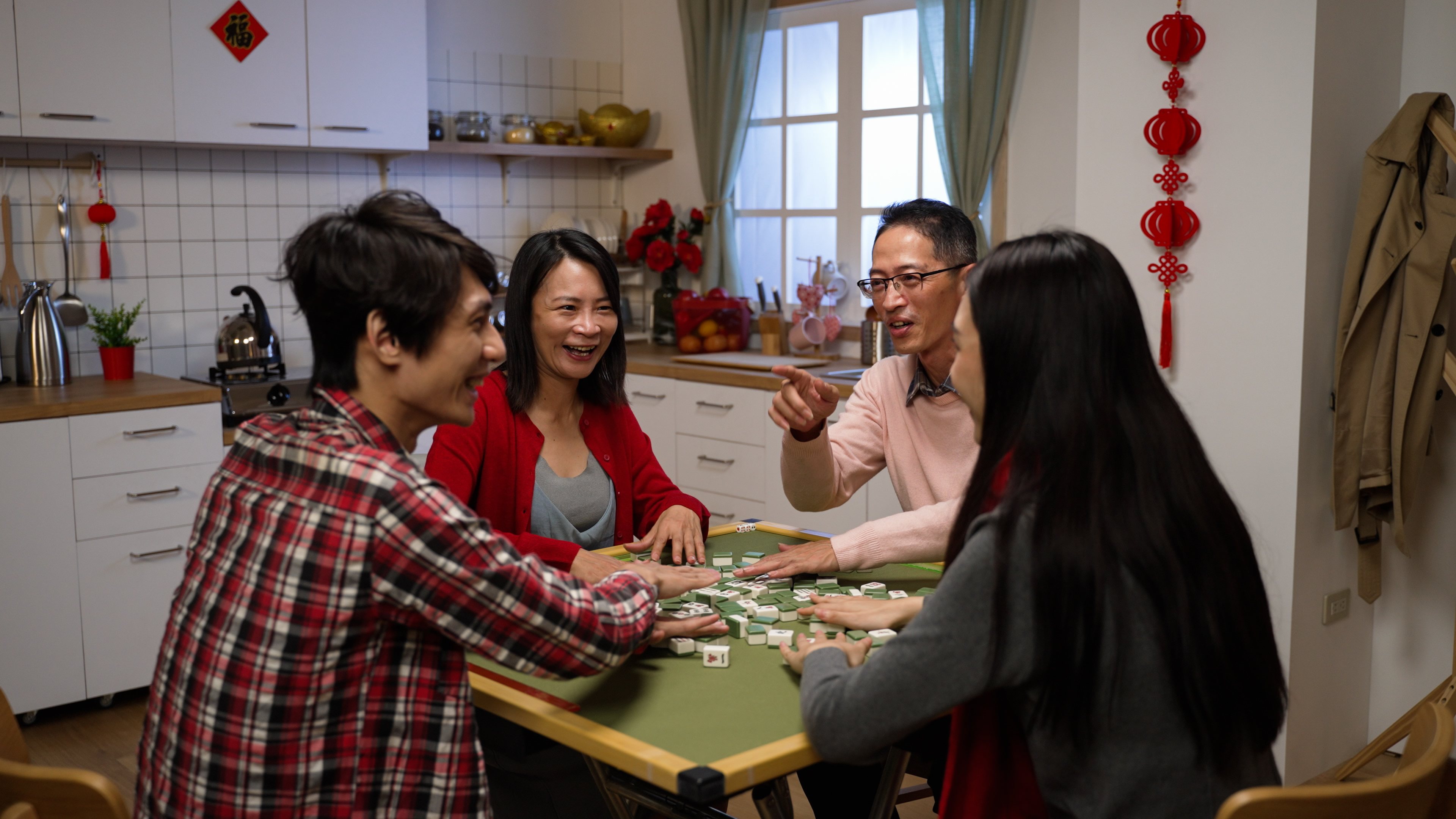 一家四口围坐在一起打麻将,在欢笑与互动中重新拉近彼此的关系,画面展现出浓厚的亲情与家庭团结的氛围。